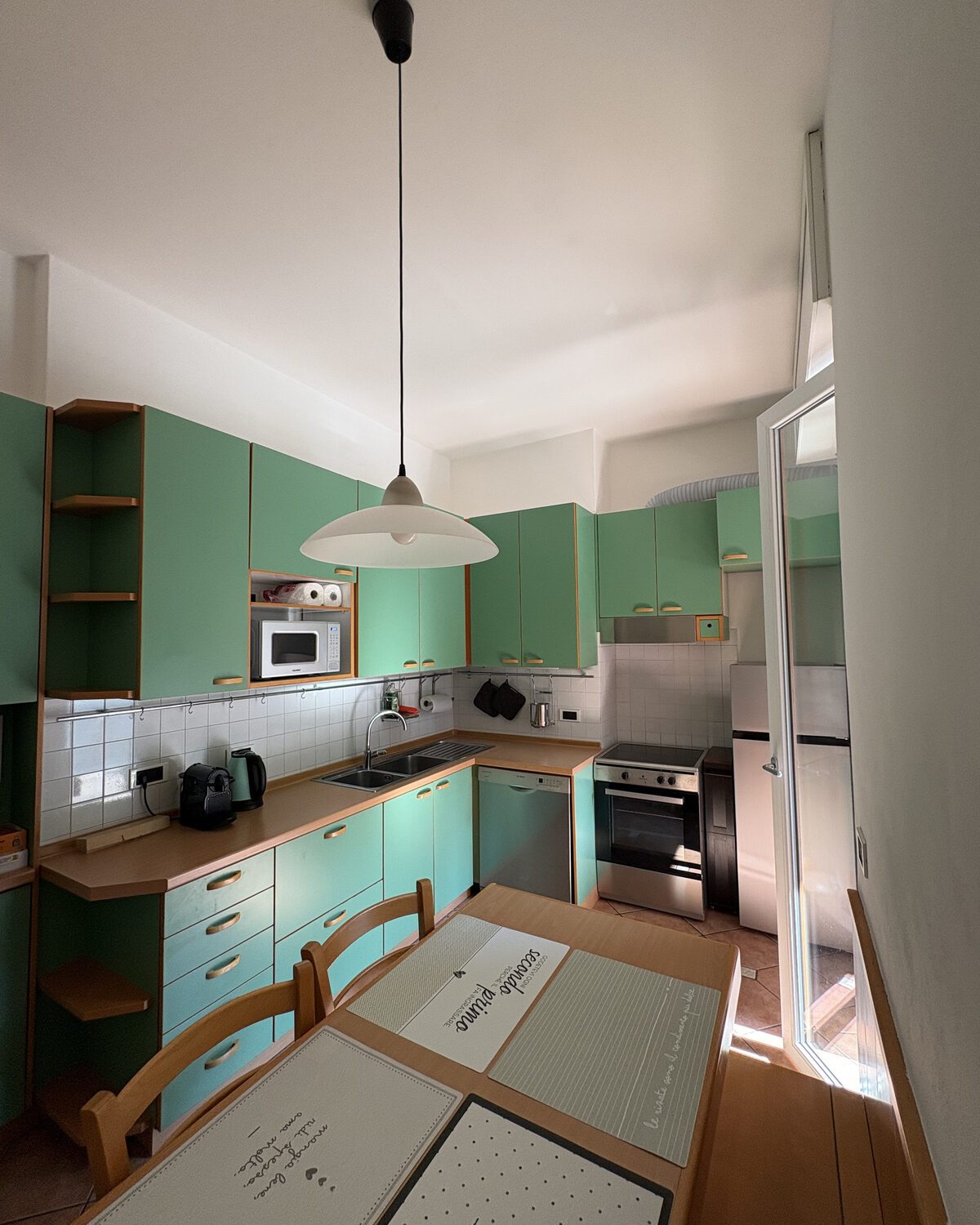 Cucina verde di La Felce con tavolo da pranzo e piano cottura a induzione Cucina verde di La Felce con tavolo da pranzo e piano cottura a induzione